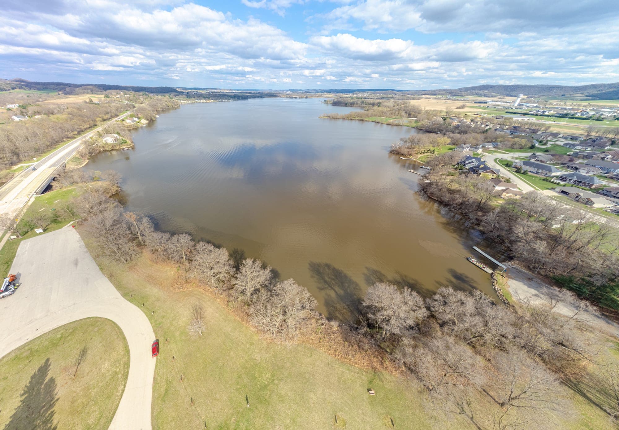 Aerial view across Lake Neshonoc with south-shore parkland and boat access in the foreground
