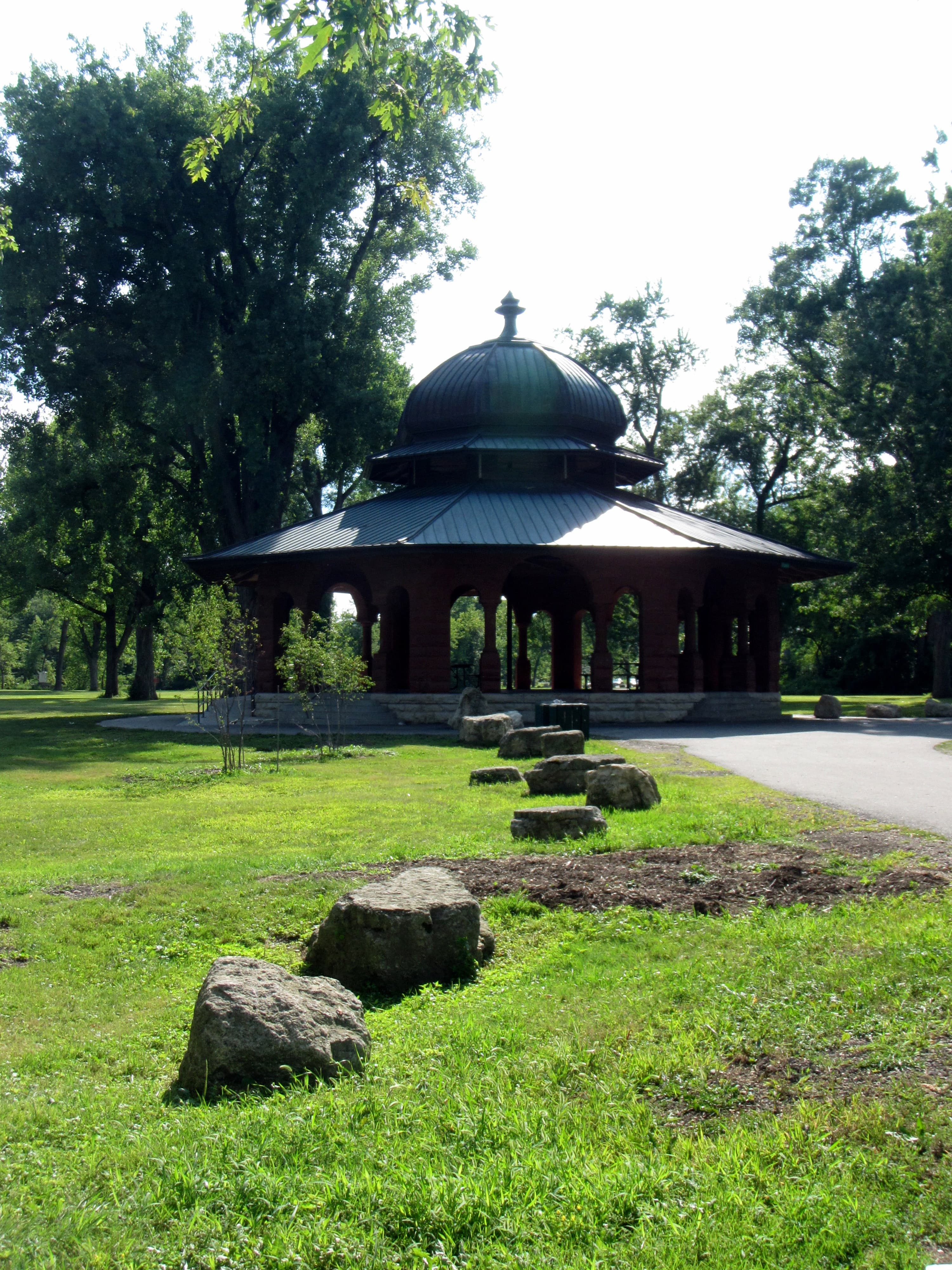 Empty historic pavilion at Pettibone Park framed by mature trees and open lawn