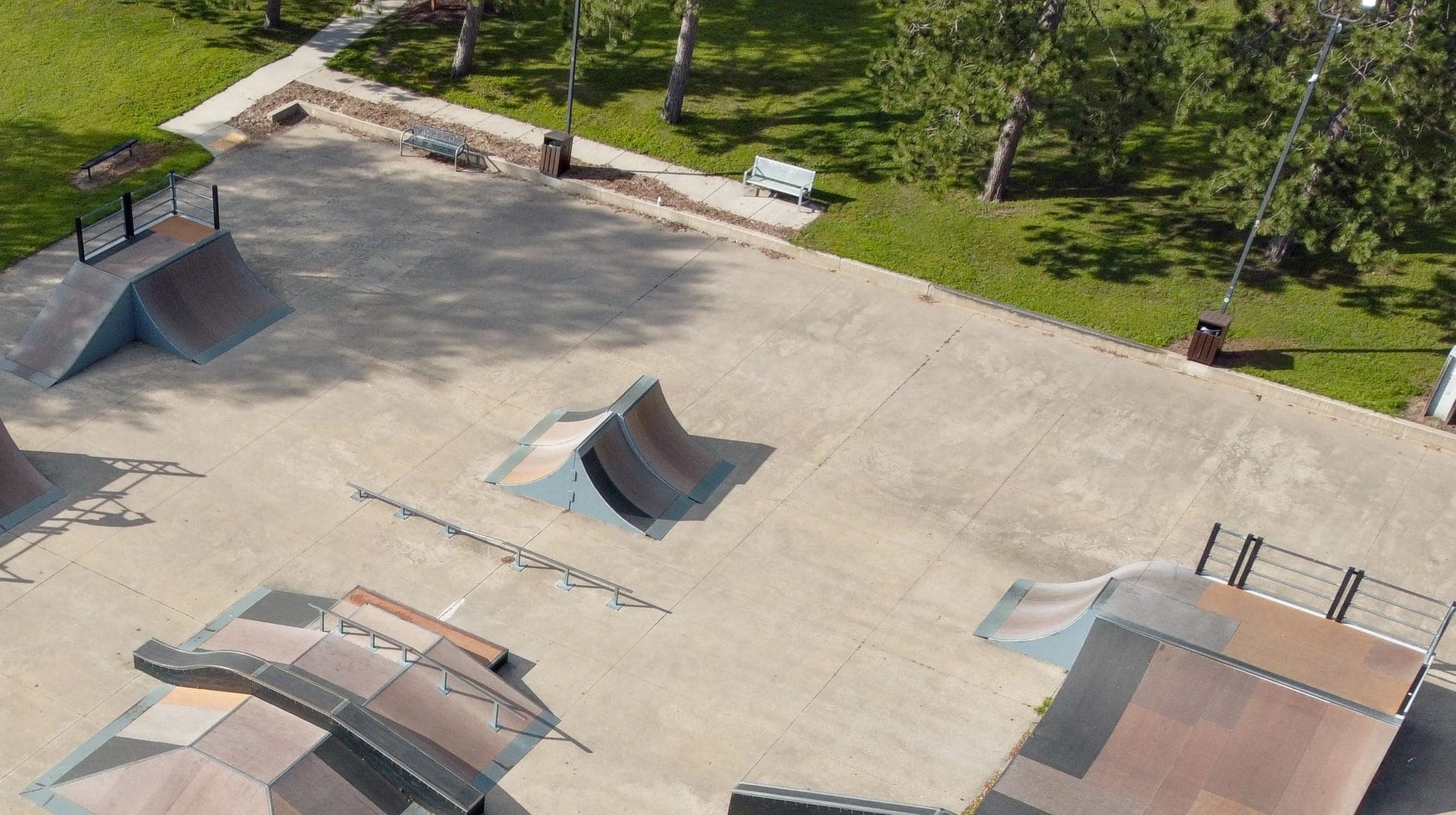 Aerial view of the empty skate park ramps and surrounding trees at Rowe Park