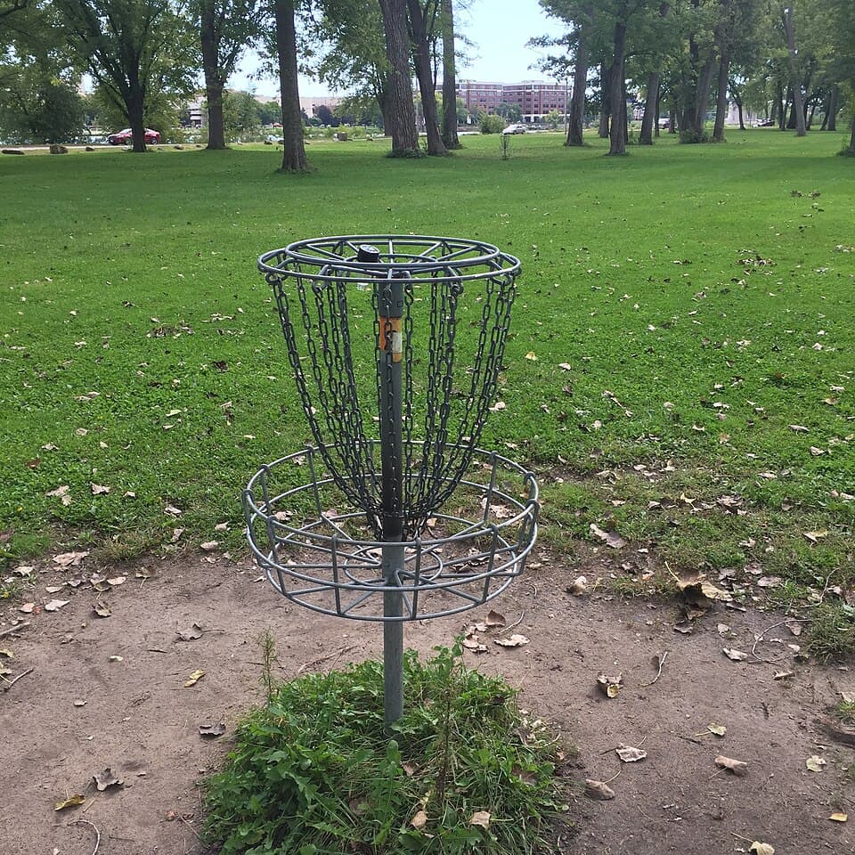 Disc-golf basket on a shaded lawn at Pettibone Park