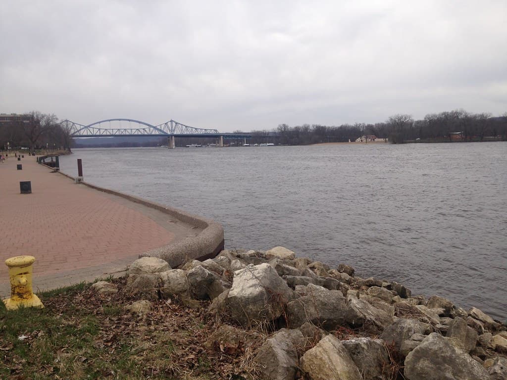 Brick riverwalk and rocky Mississippi River shoreline at Riverside Park